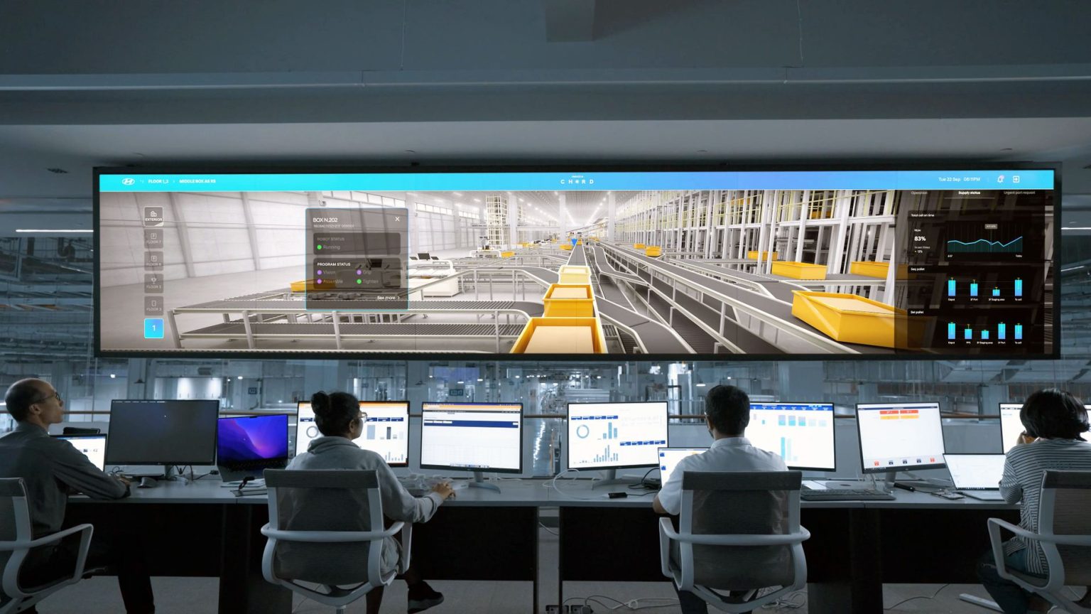 Operadores monitoram sistemas e painéis digitais em uma moderna sala de controle.