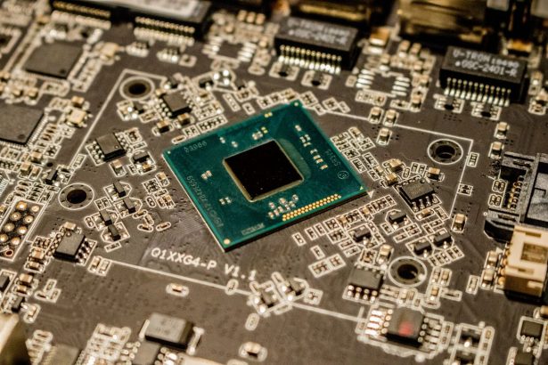 Close de um microchip instalado em uma placa de circuito, com componentes eletrônicos ao redor